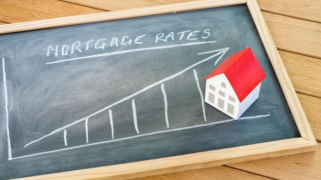 Rising mortgage rate graph on a blackboard lying on a wooden table